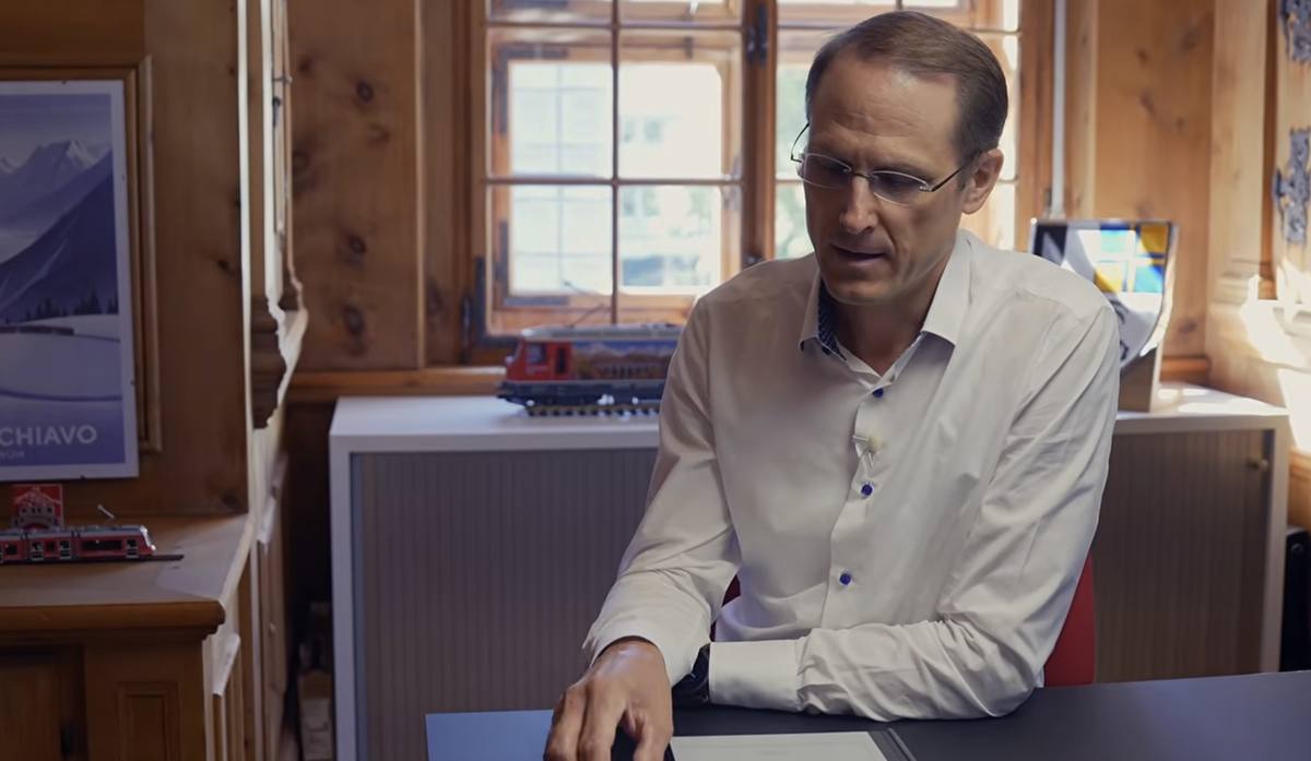 Renato Fasciati, Direktor der Rhätischen Bahn, im Gespräch an seinem Schreibtisch. Das Büro ist mit Arvenholz getäfelt, im Hintergrund stehen ein rotes Modell einer RhB-Lokomotive auf dem Sideboard un