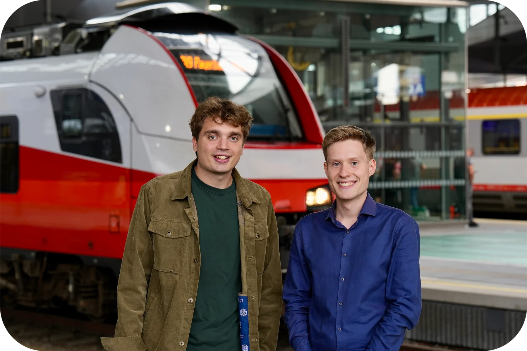 Sebastian und Paul vor einem Zug am Bahnsteig